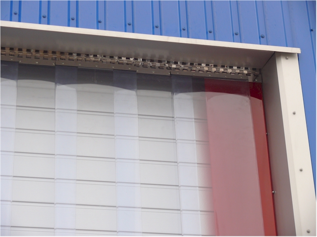 Paski folii PCV tworzące kurtynę, zamontowane w metalowej ramie, widoczne mocowania do sufitu, jeden pasek w kolorze czerwonym.